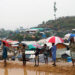 Rohingya refugees stand on the roadside with umbrellas during rain in the Balukhali refugee camp in Cox's Bazar, Bangladesh, on March 6, 2019. / Reuters