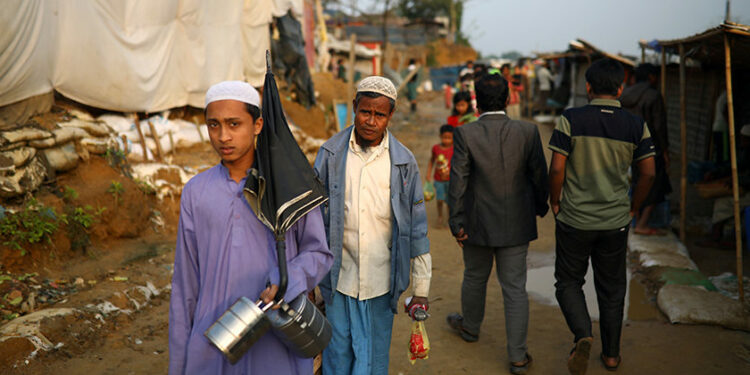 Rohingya refugees walk along a road at a refugee camp in Cox's Bazar, Bangladesh on March 6, 2019. / Reuters