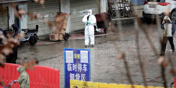 A worker in a protective suit is seen at a closed seafood market in Wuhan, China on Jan. 10, 2020. The market has been linked to the outbreak of pneumonia caused by the new strain of coronavirus. / REUTERS