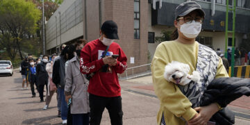 People practice social distancing as they wait to vote in South Korea's parliamentary election amid the COVID-19 pandemic, outside a polling station in Seoul on April 15, 2020. / Reuters