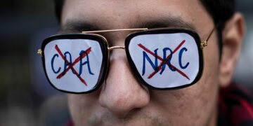 A demonstrator listens to a speaker as he attends a protest against a new citizenship law outside the Jamia Millia Islamia university in New Delhi on Dec. 22, 2019. / REUTERS