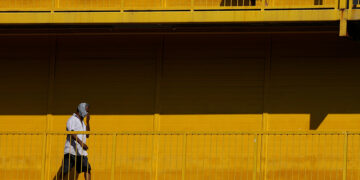 Migrant workers exercise along a walkway at a dormitory declared an isolation area during the coronavirus outbreak in Singapore on April 21. / Reuters