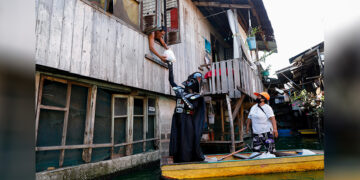 A village officer dressed as the ‘Star Wars’ character Darth Vader rides a small boat to deliver relief goods amid the COVID-19 outbreak to residents of the flooded Artex Compound in Manila, the Philippines, on May 4, 2020. / REUTERS