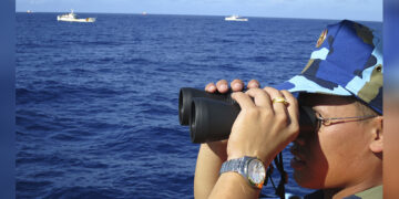 A crewman from a Vietnamese coastguard ship looks out at sea as Chinese coastguard vessels chase Vietnamese ships away from a Chinese oil rig in the South China Sea (known as the East Sea in Vietnam) in July 2014. / REUTERS