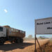 A truck passes by a sign on a road leading to a deep seaport project in Mayingyi, part of the Dawei Special Economic Zone development, on Jan. 27, 2012. / Soe Than WIN / AFP