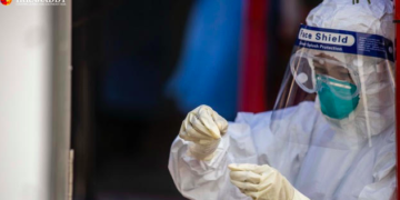 A medic takes a nasal swab from people who need to travel in December. / Htet Wai