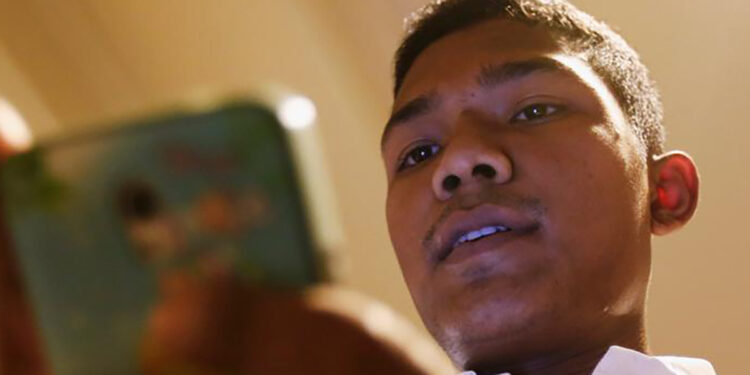 Burmese migrant worker Tun Tun Win, 24, uses his mobile phone in Bangkok, Thailand, Sept. 2, 2016. / Reuters