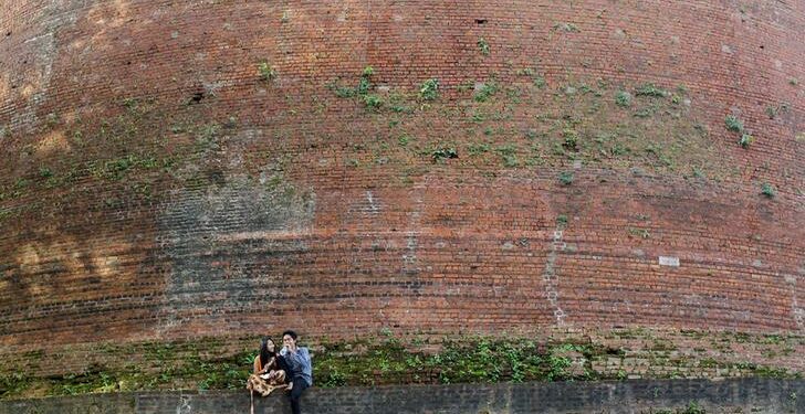 A couple passes time at a pagoda at the ancient Pyu city of Sri Ksetra, outside of Pyay, Bago Division, in August 2014. The site has been included in the UNESCO world heritage list. / Soe Zeya Tun / Reuters