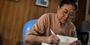 Daw Khin Khin Win signs her autograph for her memoir. / Pyay Kyaw / The Irrawaddy