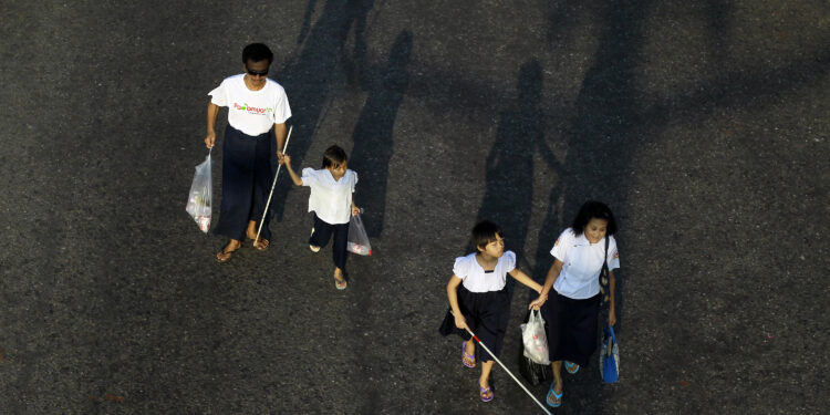 Visually impaired people walk the streets of Rangoon as they commemorate International White Cane Day, on October 15, 2012. About 760 blind and visually impaired people from around the country took part in the event. / Soe Zeya Tun / Reuters