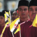 Bruneians display national flags as they march past the royal dais during the 27th celebrations of Brunei National Day in Bandar Seri Begawan February 23, 2011. / Reuters