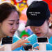 Members of staff use a smartphone at Sina Weibo's booth during the Global Mobile Internet Conference at the National Convention in Beijing on April 27. / Reuters