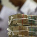 A stack of 1,000 kyat banknotes is seen as employees count money at a Yoma Bank branch in Yangon. / Reuters