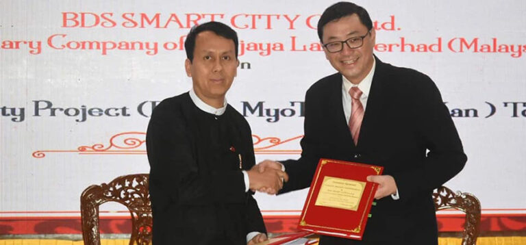 Yangon regional Chief Minister U Phyo Min Thein (left) and a representative (right) from BDS company pose for a photo after signing a concession agreement on Feb. 7 in Yangon. / Yangon regional government