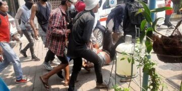 People carry a wounded protester in Thaketa Township in Yangon on Monday. / CJ.