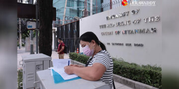 A Myanmar migrant woman fills in a form to register for early voting for the 2020 Myanmar election in front of the Myanmar Embassy in Bangkok on Tuesday. / Nyein Nyein / The Irrawaddy