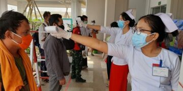 Volunteers from nursing training schools check the temperatures of migrant workers at the border control checkpoint in Myawaddy in Karen State. / Aung Thiha / The Irrawaddy