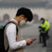 A student wearing a mask uses his mobile phone during a polluted day in Seoul, South Korea, on March 5. / Reuters