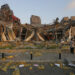 Men stand before wrecked buildings after a massive explosion in Beirut, Lebanon on Tuesday. / Getty / Kyodo