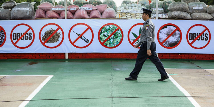 A police officer walks past seized drugs before they are destroyed on the International Day Against Drug Abuse and Illicit Trafficking on June 26, 2016. / The Irrawaddy