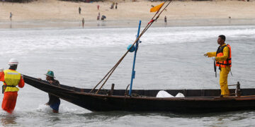 Rescue workers on a boat bring dead bodies to the beach after a military plane crashed, outside Launglon Township, Myanmar on June 8, 2017. / Soe Zayar Tun / Reuters
