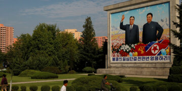 Residents pass by a painting featuring late North Korean leaders Kim Il-sung (L) and Kim Jong-il ahead of 70th anniversary of North Korea's foundation in Pyongyang, September 6, 2018. / REUTERS