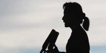 Aung San Suu Kyi’s silhouette is seen in profile as she speaks at a rally for constitutional reform in Loikaw, Karenni State, on Nov. 8, 2014. / The Irrawaddy