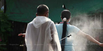 A disease control worker sprays disinfectant on a migrant worker at a field hospital in Samut Sakhon province on Jan 10. / Bangkok Post