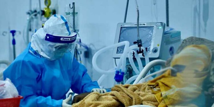 A medic treats a COVID-19 patient at the temporary Ayeyarwady hospital in Mandalay. / Ministry of Health and Sports.