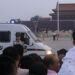 A paramilitary police officer stands guard in front of a police vehicle as people wait for the flag-raising ceremony held at Tiananmen Square during sunrise, in Beijing, China on June 4, 2019. / REUTERS