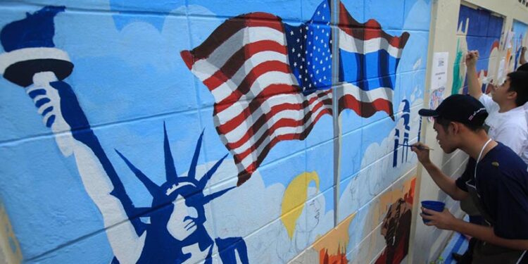 Students add the finishing touches to a painting on the walls of the US Embassy in Bangkok depicting the national flags of Thailand and the US, and the Statue of Liberty. The painting was created to mark the 180th anniversary of relations between the two countries. / Bangkok Post