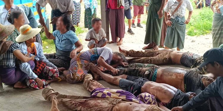 People mourn over the bodies of 26 resistance fighters and civilians found on Saturday. / Supplied