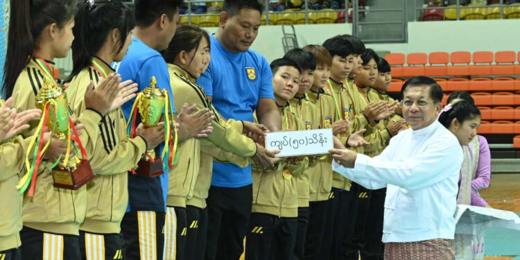 Min Aung Hlaing hands prizes to winners at a volleyball tournament in Naypyitaw on Thursday. / Cincds